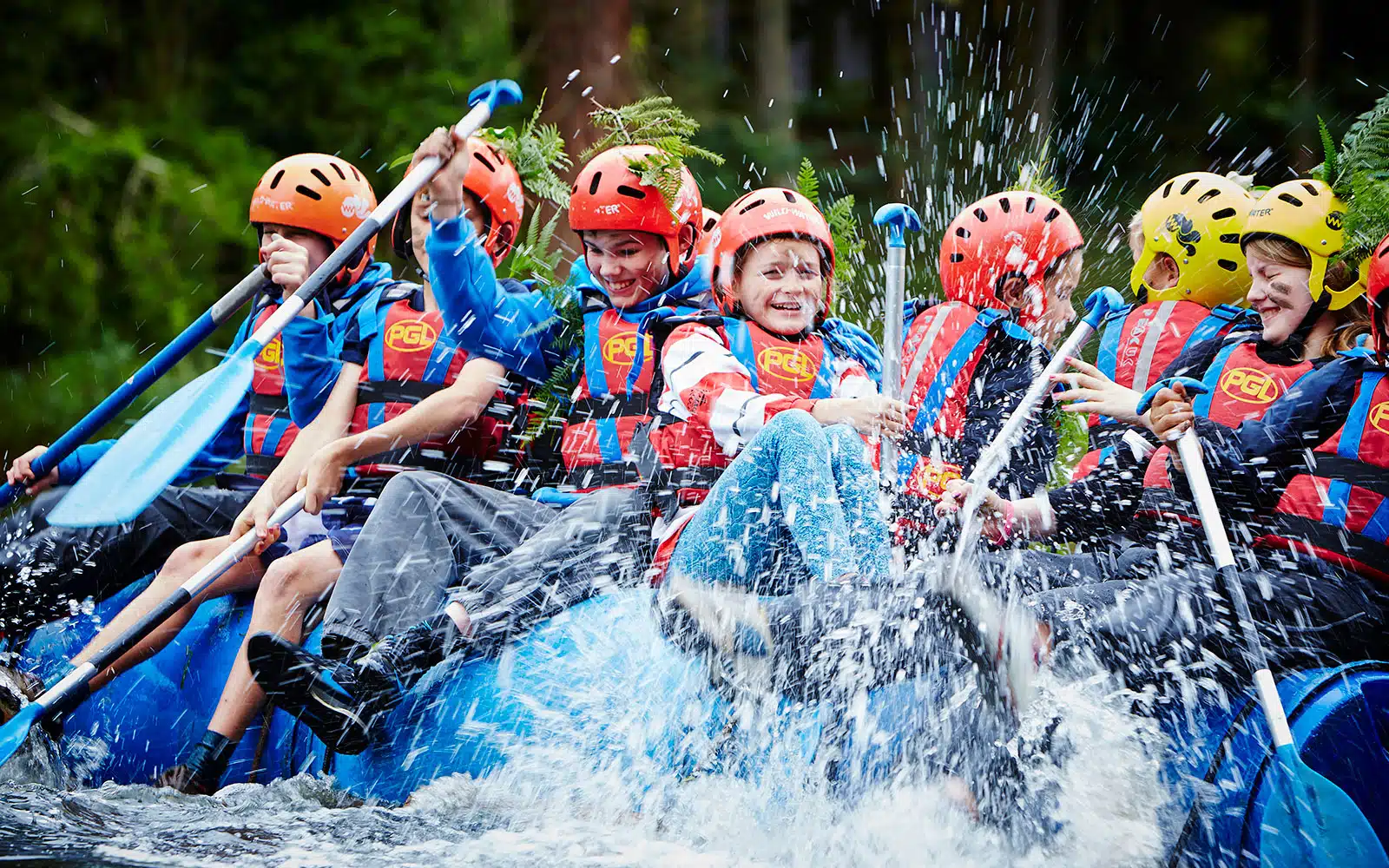 Kids splashing water with paddels on a raft