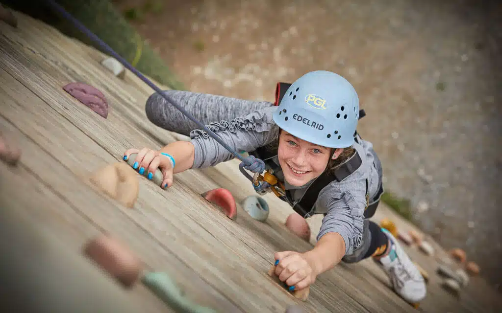 Girl climbing a climbing tower at Liddington Activity Centre
