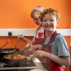 Young boy cooking in a frying pan