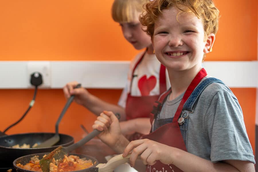 Young boy cooking in a frying pan