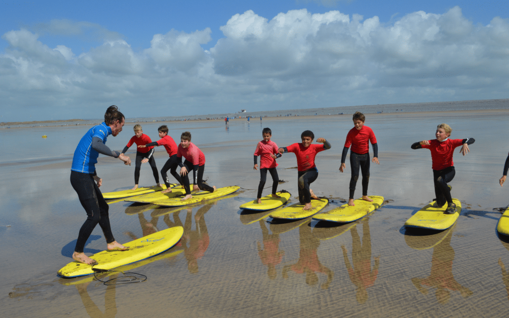 children being taught to stand up on surf boards
