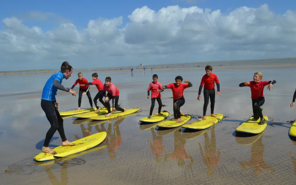 children being taught to stand up on surf boards
