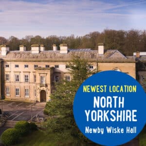 A large building with a classical facade, surrounded by trees, and text on the image stating "Newest location North Yorkshire Newby Wiske Hall.