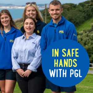 Four people wearing PGL uniforms stand outside near a coast. The text on a circular overlay reads, "In Safe Hands with PGL.