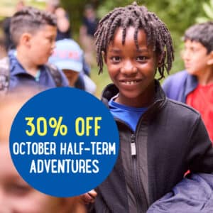 Group of children outdoors with a text overlay reading "30% OFF October Half-Term Adventures.