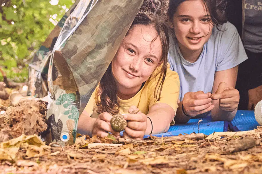 Two girls lying under a tent.