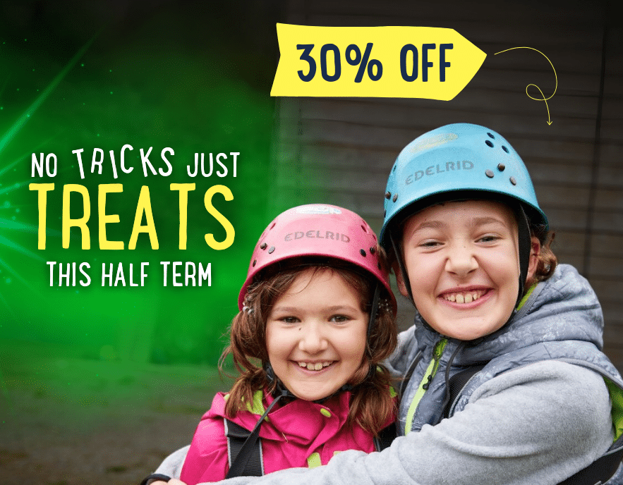 Two children in helmets smiling and hugging outdoors, with text promoting “No tricks just treats this half term” and a “30% off” discount on PGL Adventure Holidays.