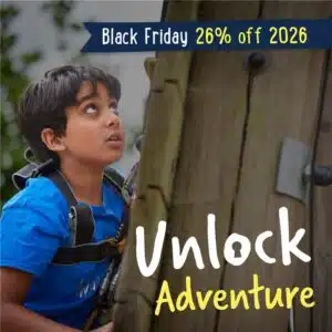 A boy in a blue shirt and harness climbs a wooden wall. Text overlay reads "Black Friday 26% off 2026" and "Unlock Adventure.