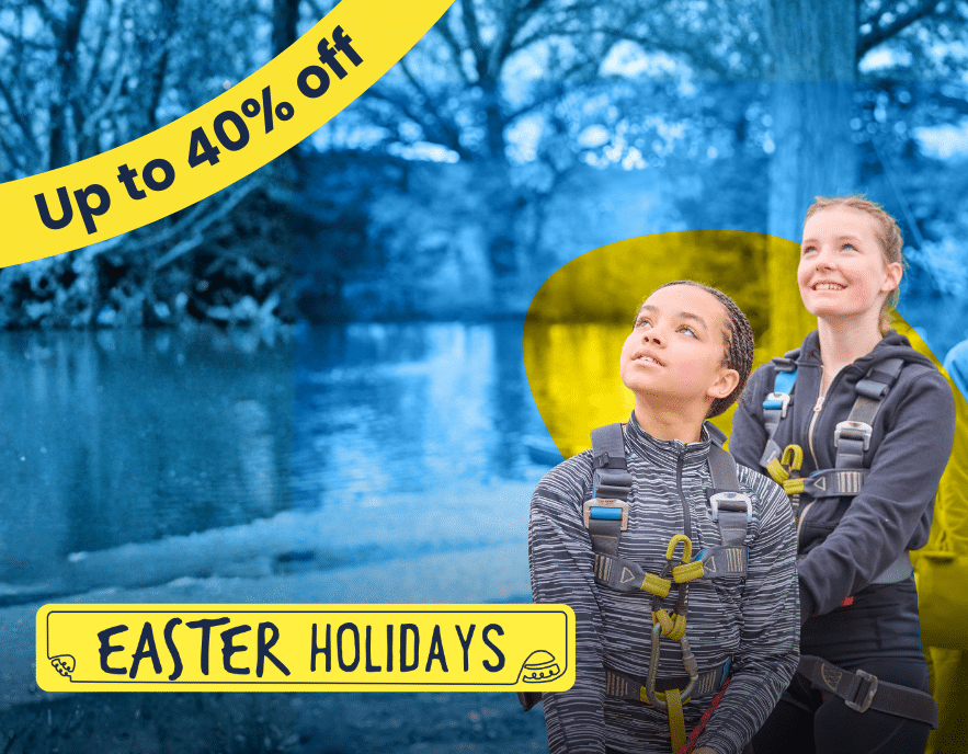 Two girls in harnesses stand outdoors near water, looking up; yellow banners read “Up to 40% off” and “Easter Holidays”—the perfect time to book your PGL Adventure Holidays.