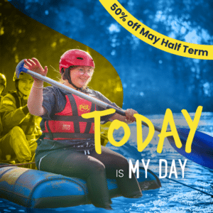 A person in safety gear paddles a raft on water, smiling. Text reads "Today is my day" and "50% off May Half-term" in a yellow banner.