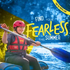 A young woman wearing a helmet and life jacket paddles a raft on water; text reads "Find your fearless this summer" and "Up to 50% off.