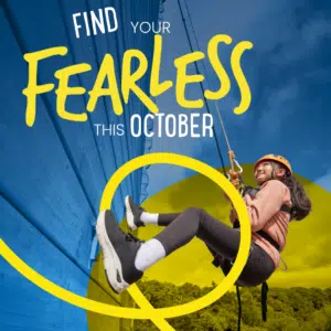 A young woman in safety gear climbs a blue wall outdoors. Text reads, “Find your fearless this October.” Yellow design elements overlay the image.